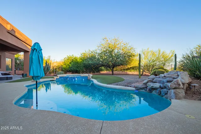 a aerial view of a house with swimming pool lawn chairs and a yard