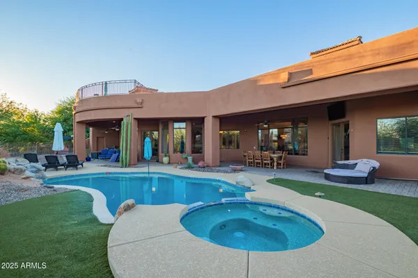 a front view of a house with a yard and potted plants