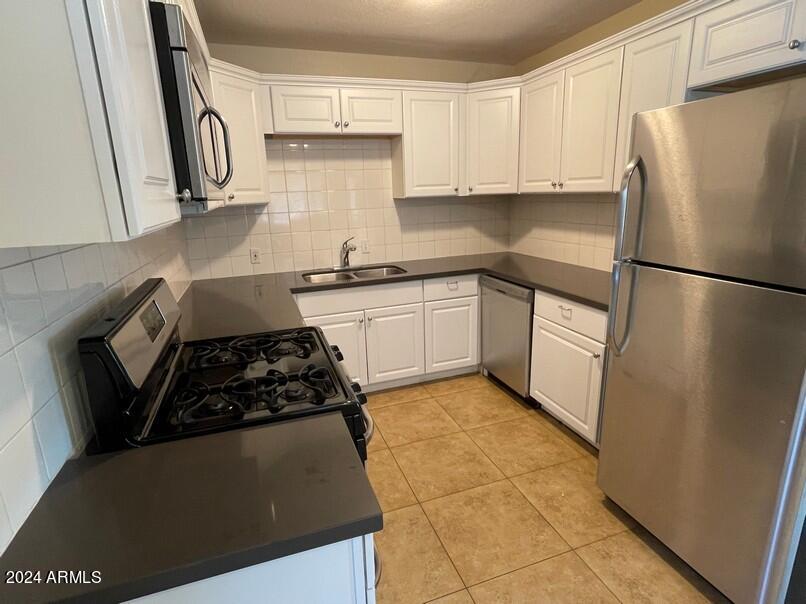3111 North 34th Street Phoenix, AZ 85018 - Photo 11 of 15 a kitchen with a refrigerator sink and cabinets