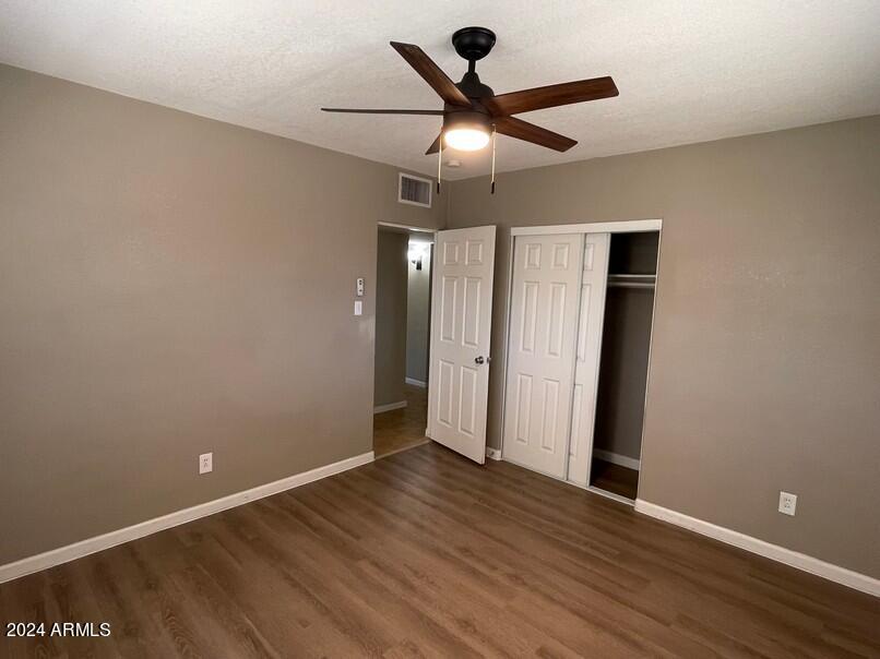 3111 North 34th Street Phoenix, AZ 85018 - Photo 8 of 15 an empty room with wooden floor and a ceiling fan