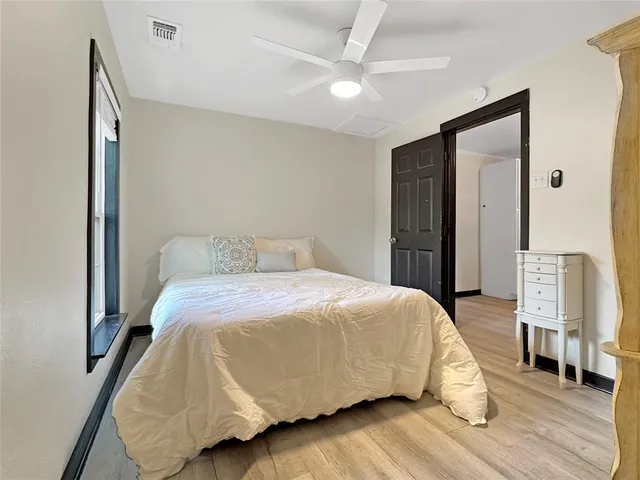 a bedroom with a bed and wooden floor