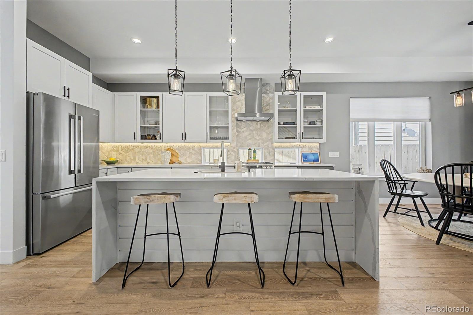 8 South Colorado Boulevard Denver, CO 80246 - Photo 2 of 40 a kitchen with stainless steel appliances granite countertop a table chairs stove and refrigerator