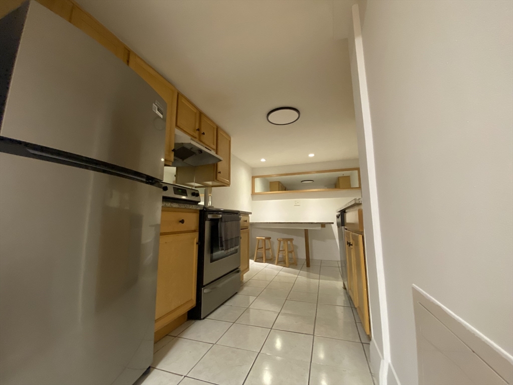 90 Bynner Street, Unit B Boston, MA 02130 - Photo 2 of 15 a kitchen with granite countertop a refrigerator and a stove