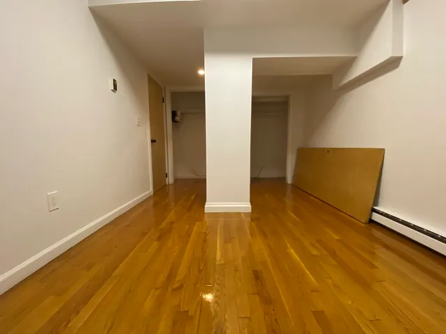 a view of an empty room with wooden floor
