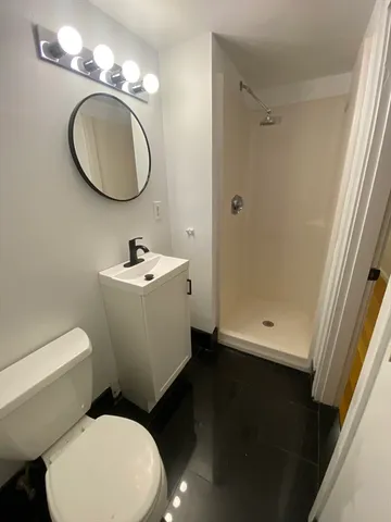 a bathroom with a sink toilet and shower