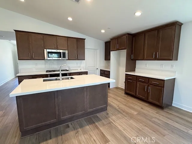 a kitchen with stainless steel appliances wooden cabinets a sink and a stove