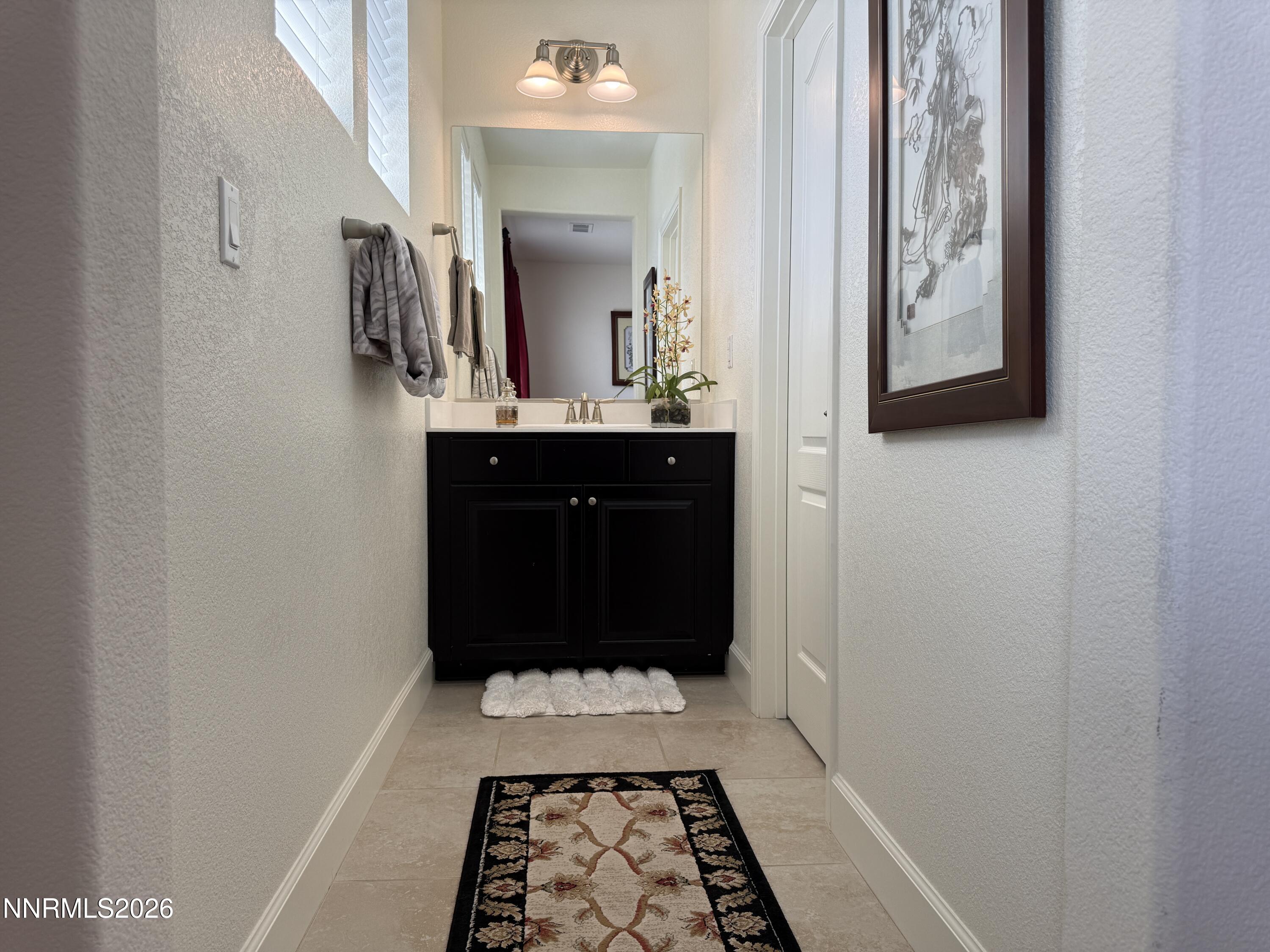 9766 Pachuca Drive Reno, NV 89521 - Photo 35 of 59 a room with a mirror and a sink