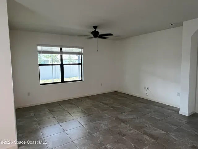a view of room with window and a ceiling fan