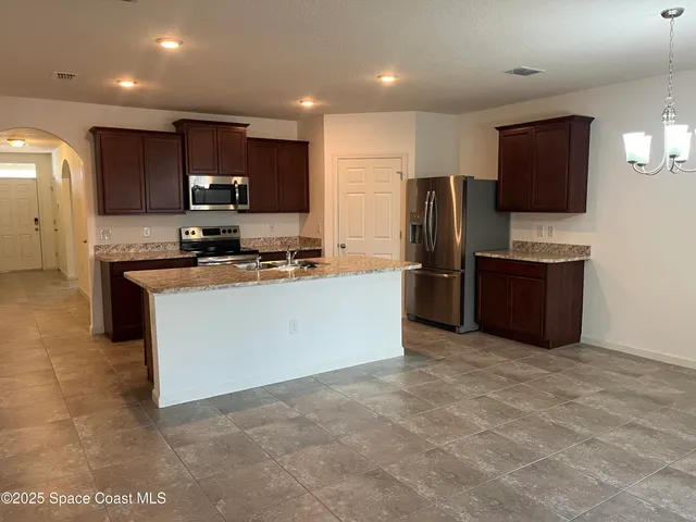 a view of a patio with table and chairs and potted plants