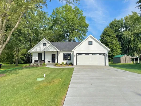 a front view of a house with a yard and trees