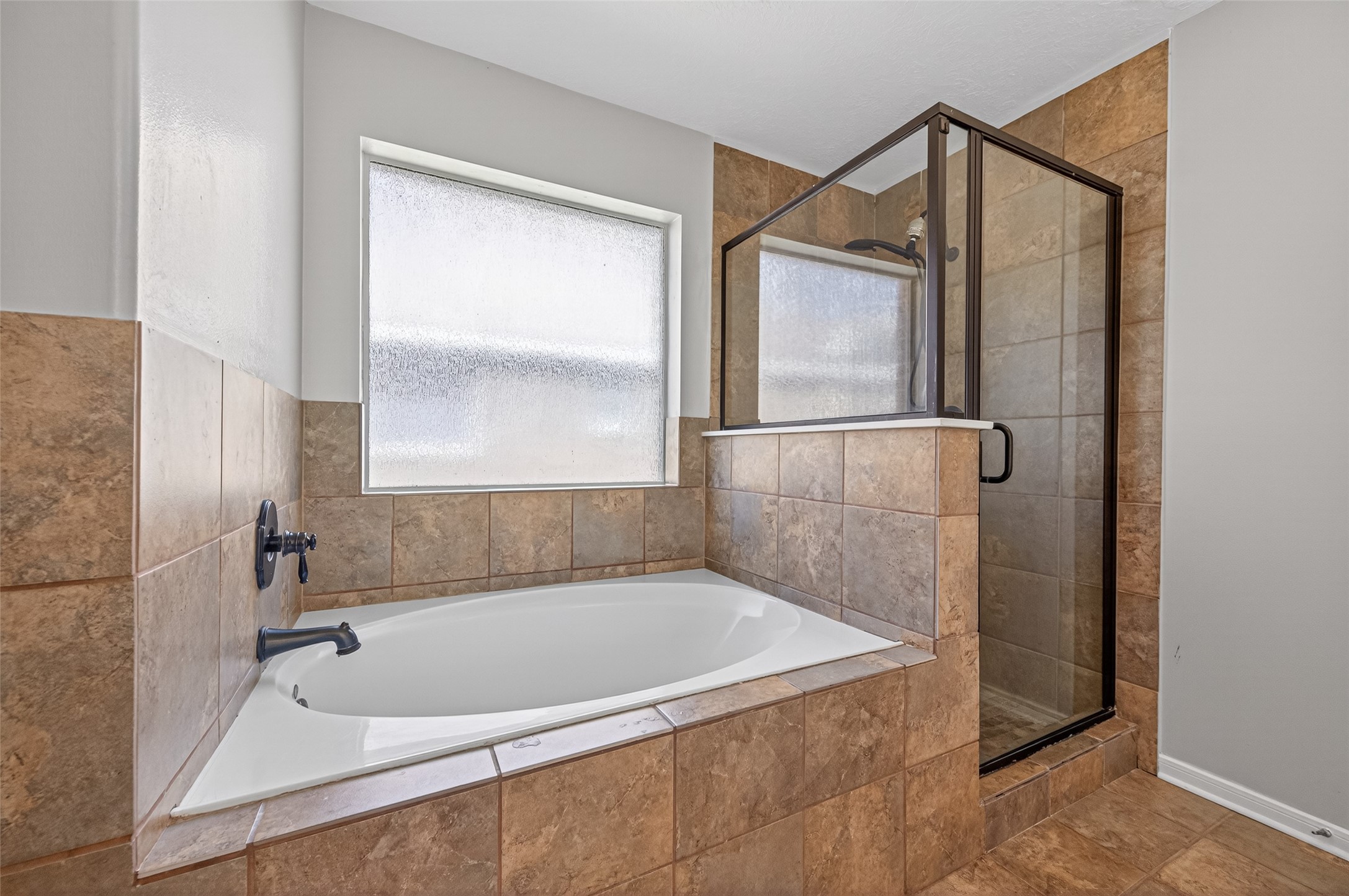 22419 Bridgestone Ridge Drive Spring, TX 77389 - Photo 27 of 48 a bathroom with a tub and a shower