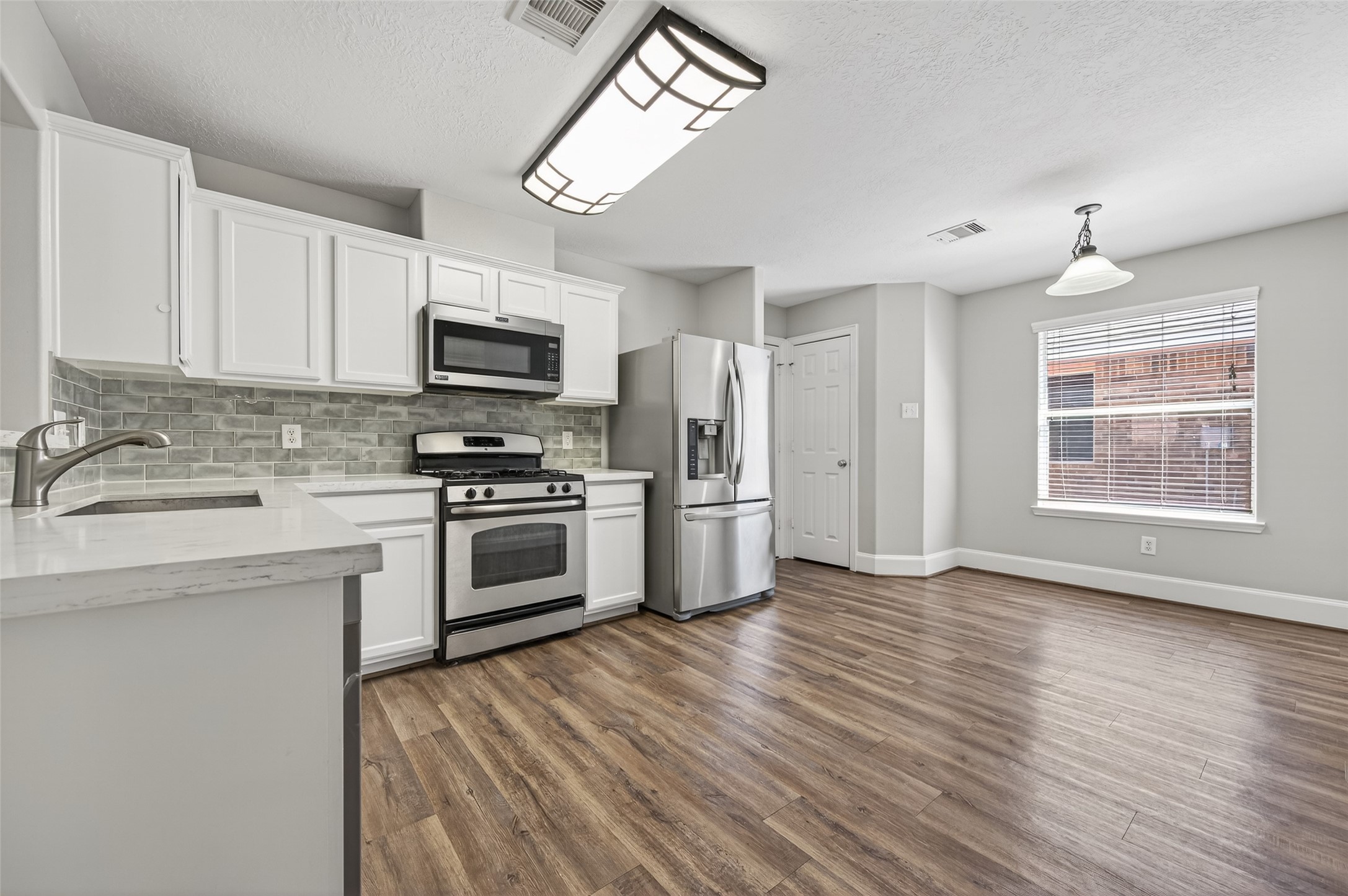 22419 Bridgestone Ridge Drive Spring, TX 77389 - Photo 10 of 48 a kitchen with granite countertop a stove a sink and a microwave