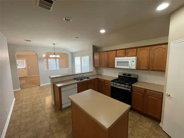 a kitchen with granite countertop a stove top oven and sink