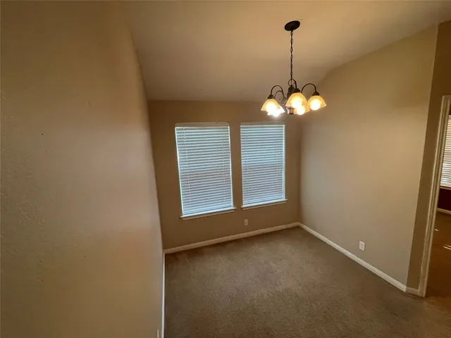a view of a room with a chandelier fan and windows