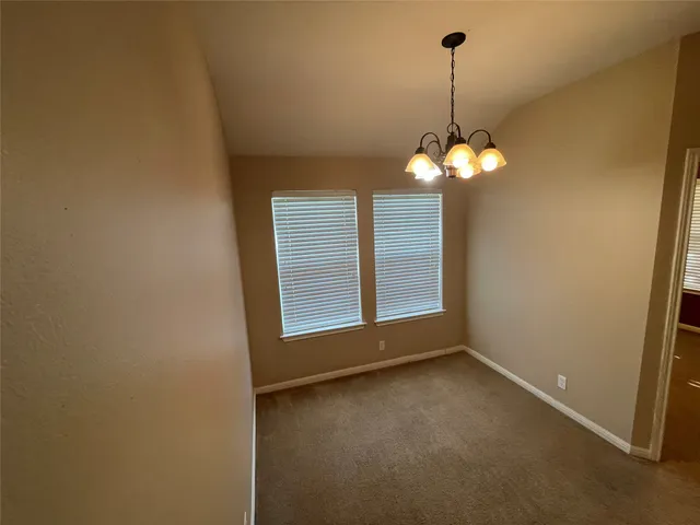 a view of a room with a chandelier fan and windows