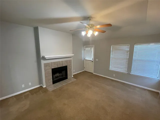 a view of empty room with fireplace and fan