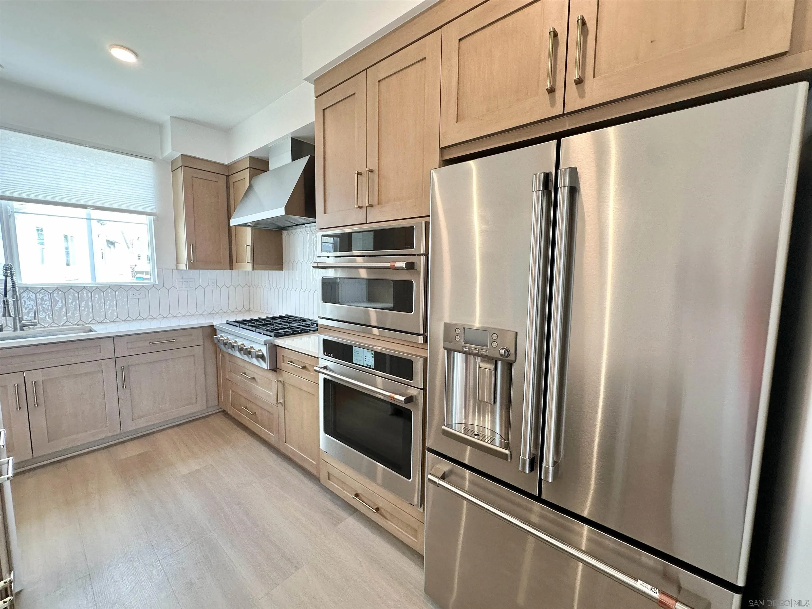 7290 Ponto Drive West, Unit 7132 Carlsbad, CA 92011 - Photo 15 of 44 a kitchen with stainless steel appliances a refrigerator sink and cabinets
