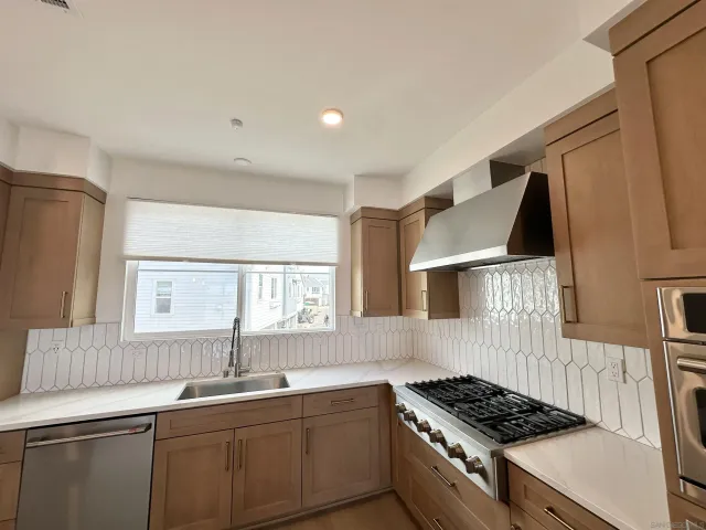 a kitchen with granite countertop stainless steel appliances and white cabinets
