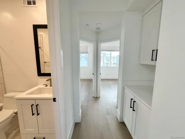 a bathroom with a bathtub shower sink vanity mirror and toilet