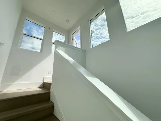 a view of a house with a barbeque and large trees