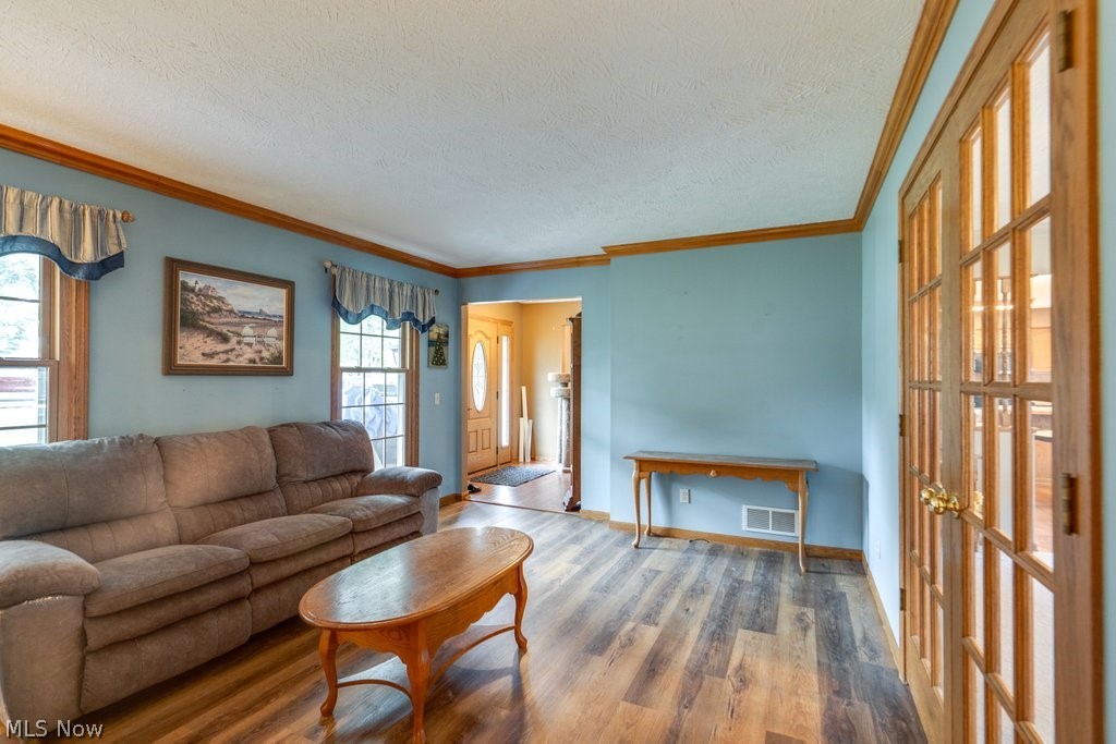 826 Stewart Road Kent, OH 44240 - Photo 14 of 43 Living room featuring crown molding, a textured ceiling, and hardwood / wood-style floors