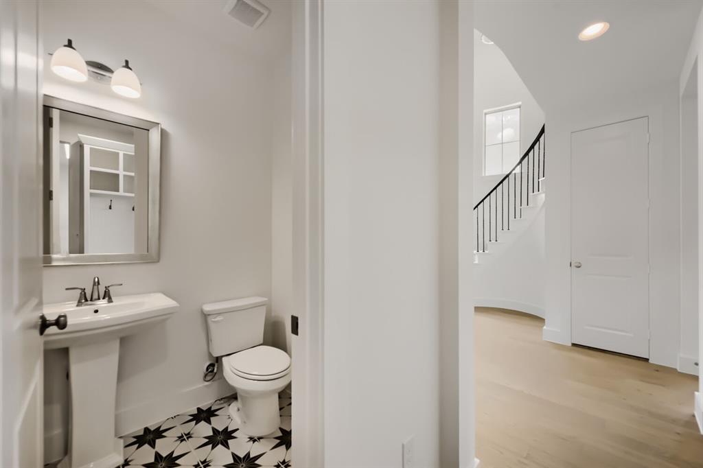 11465 Wulstone Road Fort Worth, TX 76052 - Photo 12 of 27 Pedestal sink with a coordinating toilet, framed mirror, and two-light vanity fixture