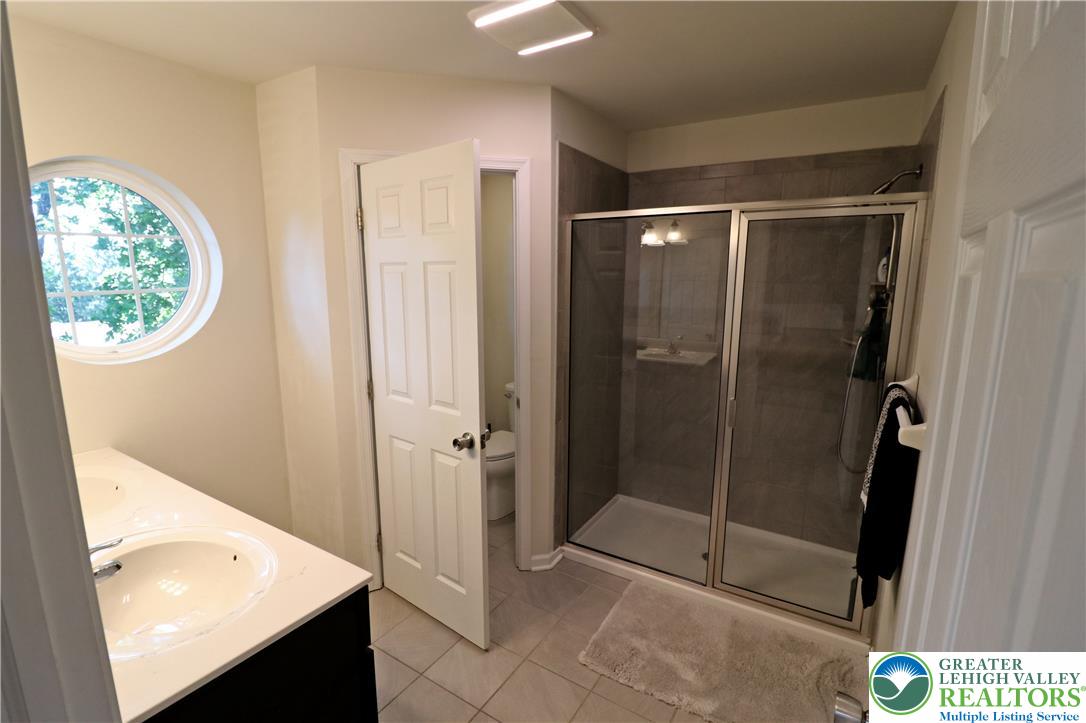 4502 Benjamin Court Emmaus, PA 18049 - Photo 28 of 53 A well-appointed bathroom features a modern shower enclosure and a unique circular window.