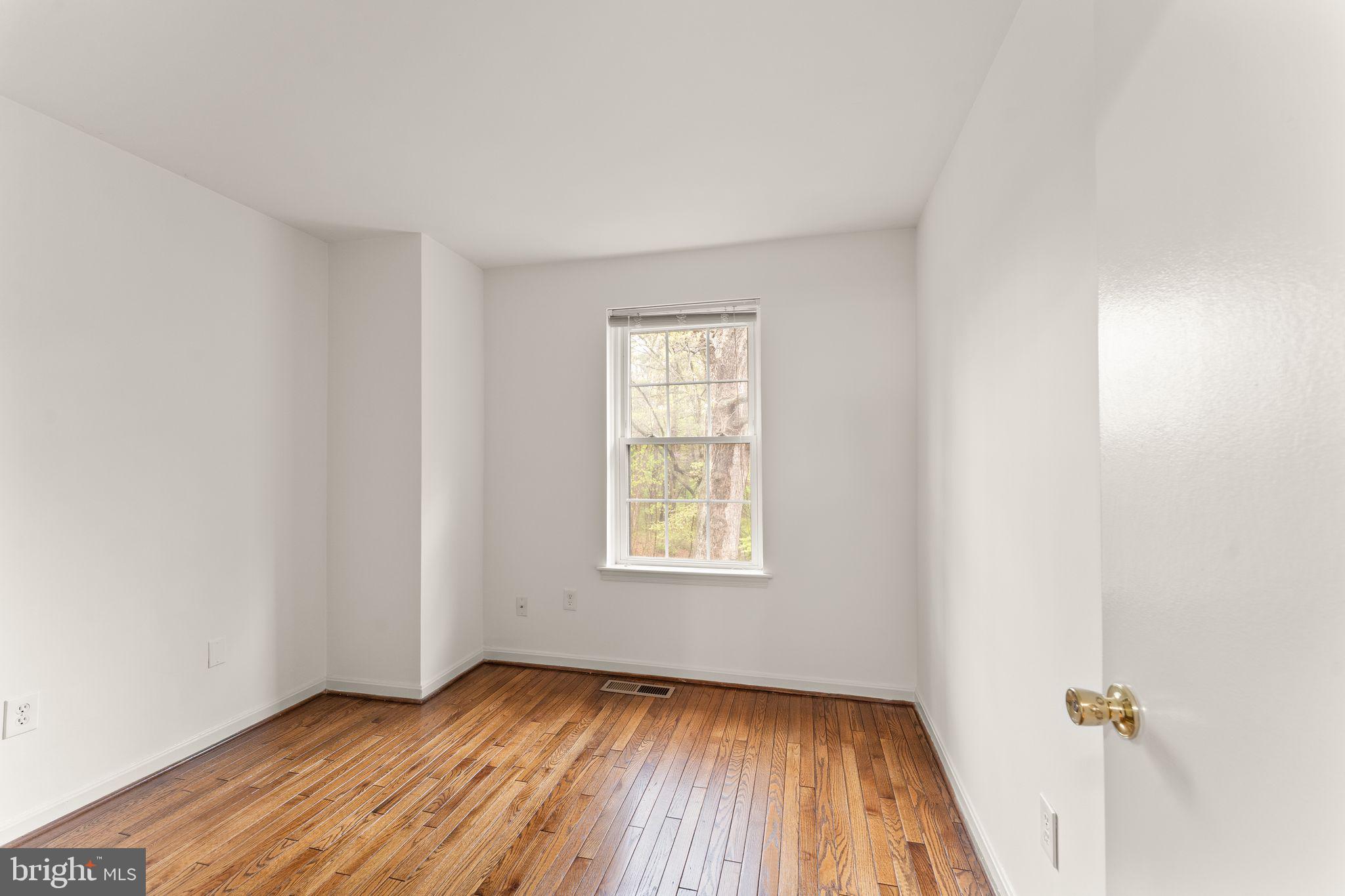 2212 Golf Course Drive Reston, VA 20191 - Photo 26 of 49 an empty room with wooden floor and windows
