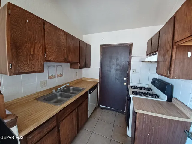 a kitchen that has a sink and a stove in it