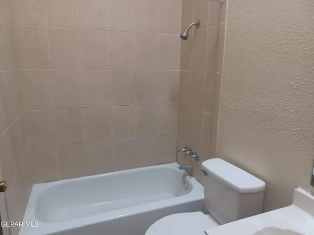 a white toilet and tub sitting next to a bathroom sink