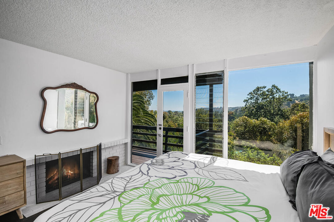 3557 Serra Road Malibu, CA 90265 - Photo 22 of 32 a bed sitting in a bedroom next to a window