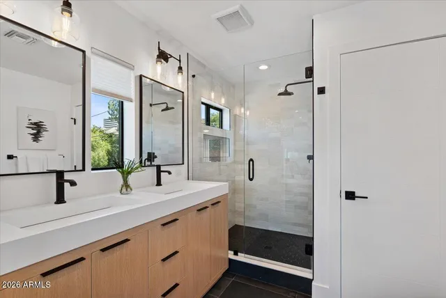 a bathroom with double vanity sink and mirror