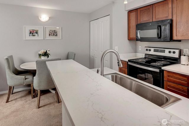 a kitchen with stainless steel appliances a stove a sink a microwave and cabinets