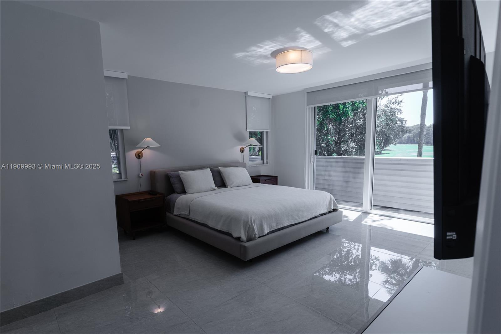 4017 North Cypress Drive, Unit 201 Pompano Beach, FL 33069 - Photo 18 of 44 a bedroom with a bed lamp and window