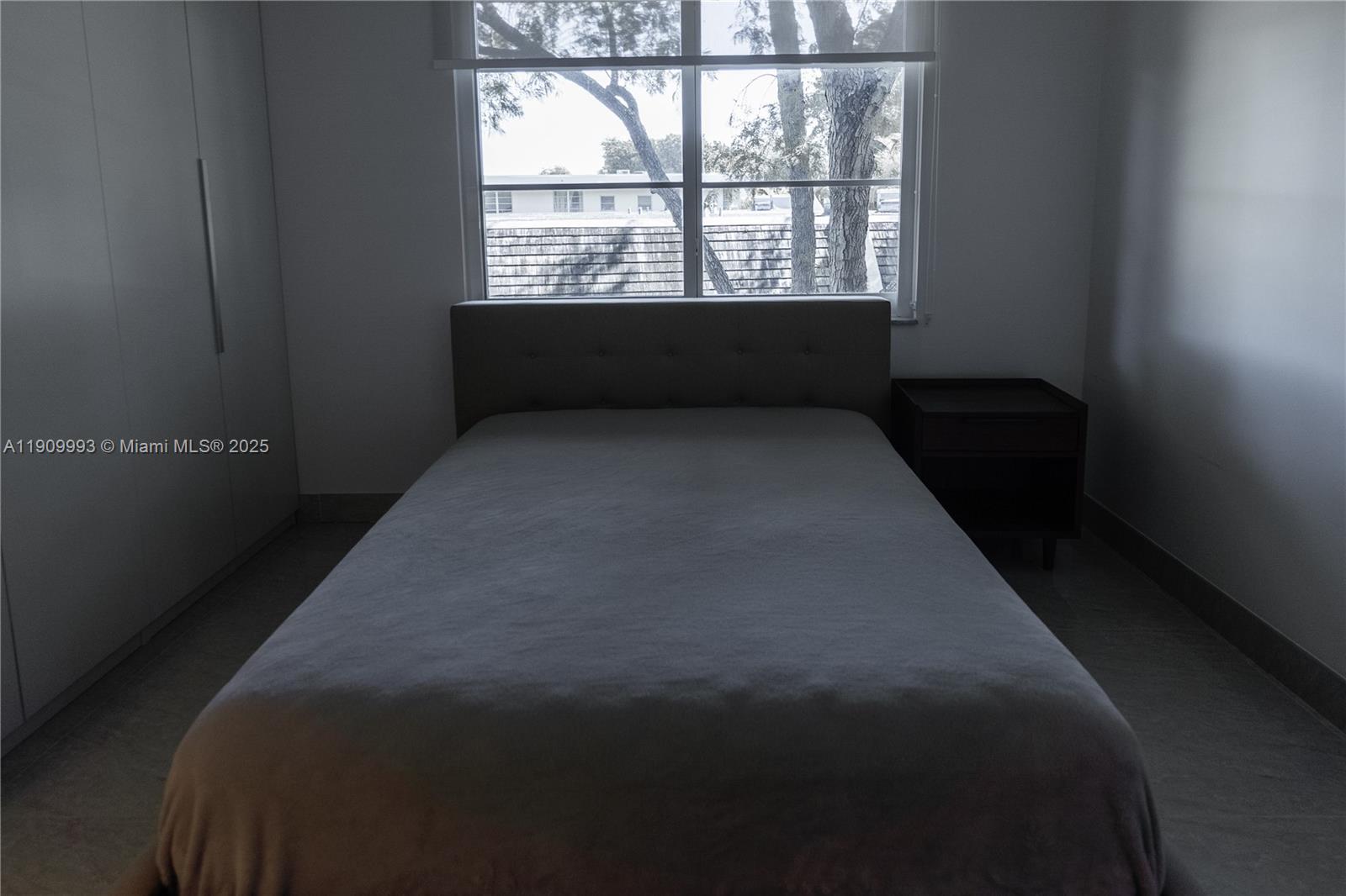 4017 North Cypress Drive, Unit 201 Pompano Beach, FL 33069 - Photo 32 of 44 a bed sitting in a bedroom next to a window