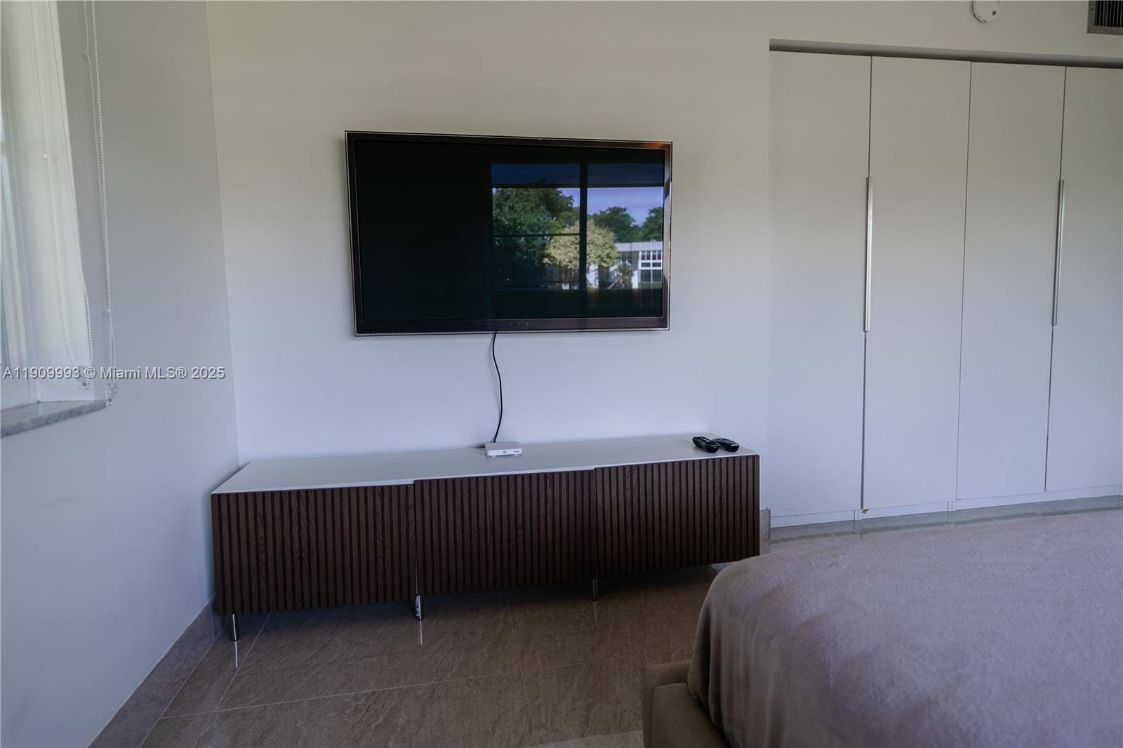 4017 North Cypress Drive, Unit 201 Pompano Beach, FL 33069 - Photo 40 of 44 a living room with a bed furniture and a flat screen tv