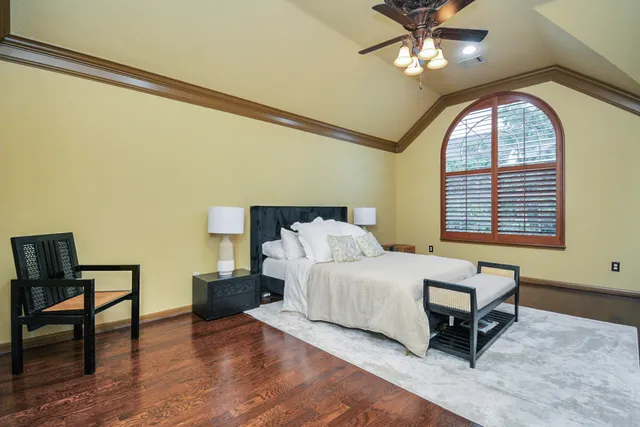 a bedroom with a bed a table and a potted plant