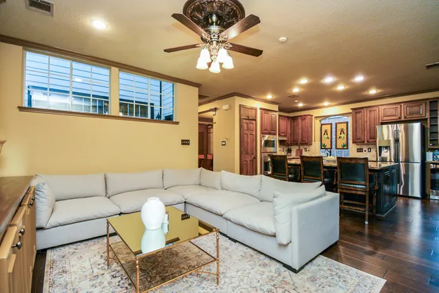 a living room with furniture kitchen view and a chandelier