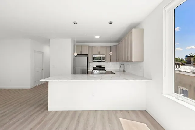 a large white kitchen with wooden floors