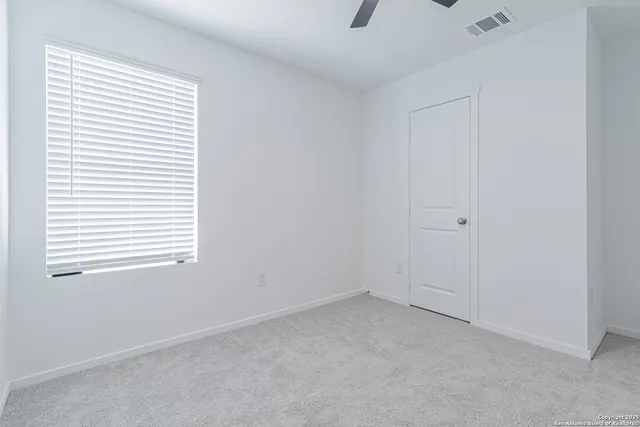 an empty room with a chandelier fan