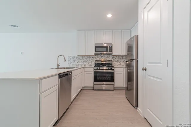 a kitchen with stainless steel appliances a refrigerator stove and sink