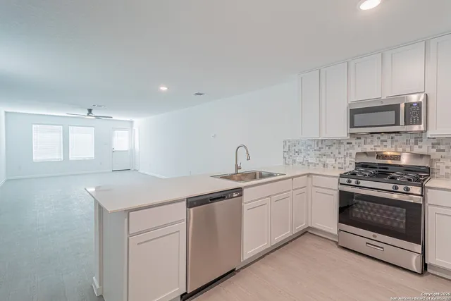 a kitchen with white cabinets stainless steel appliances and sink