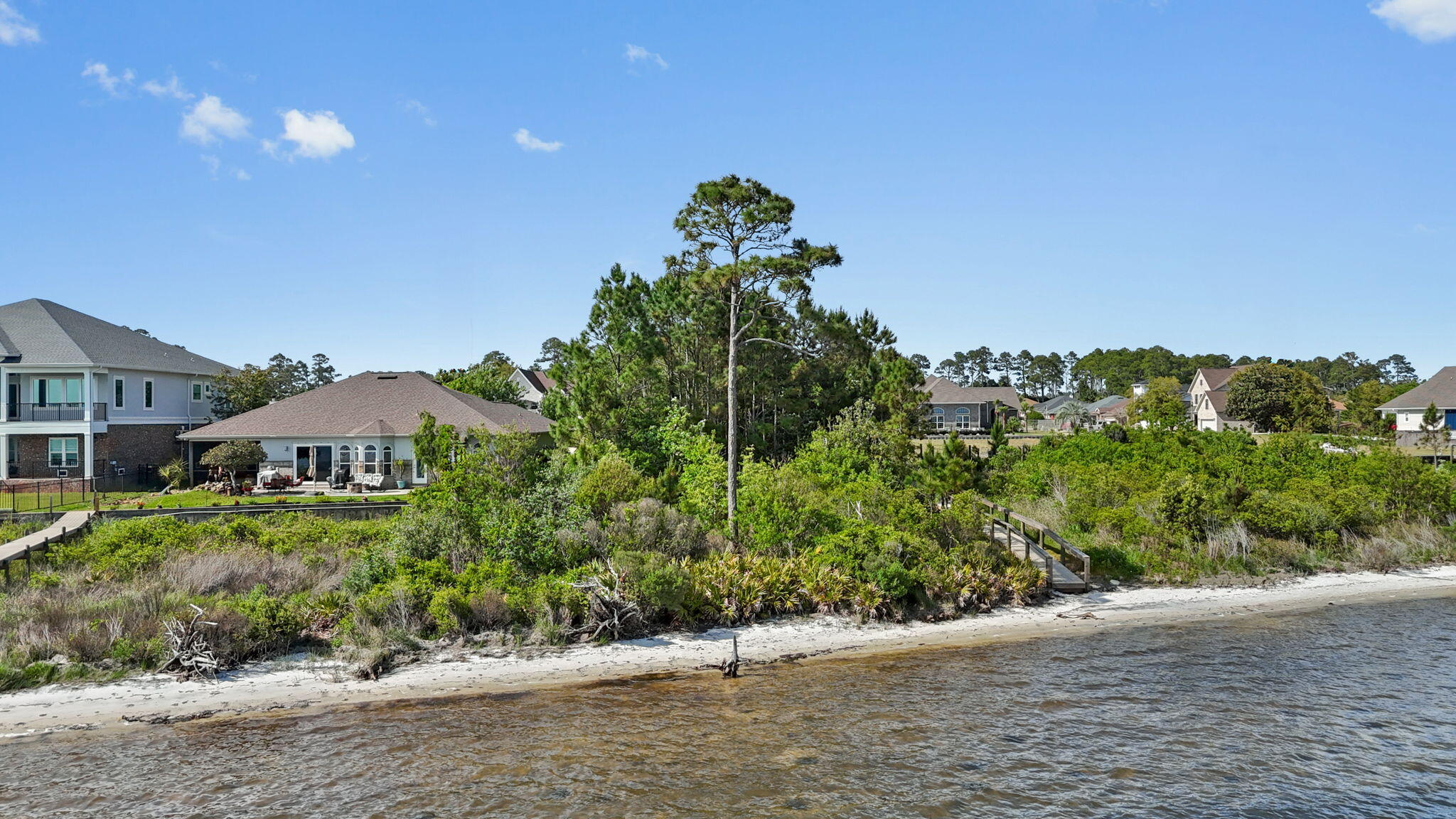 7475 Soundshore Drive Navarre, FL 32566 - Photo 25 of 35 a view of a garden with a building in the background