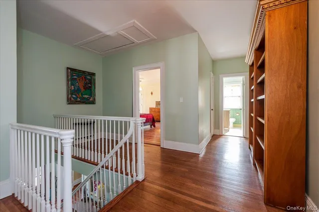 a view of a hallway with wooden floor and windows