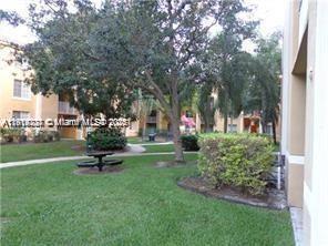 777 Southwest 111th Way, Unit 104 Pembroke Pines, FL 33025 - Photo 16 of 20 a view of a park with bench and trees
