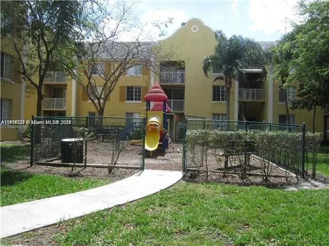 a view of house with backyard and a slide