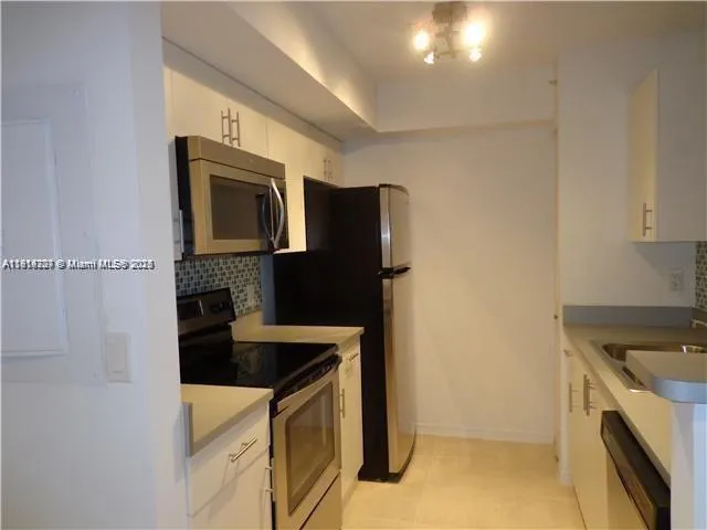 a kitchen with cabinets and steel stainless steel appliances