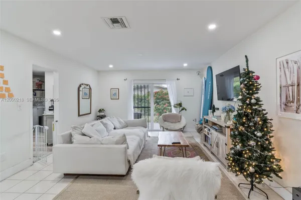 a living room with furniture a large window and a potted plant