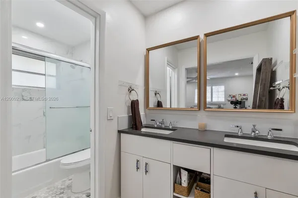 a bathroom with a granite countertop sink toilet and shower