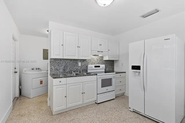 a kitchen with white cabinets and white appliances